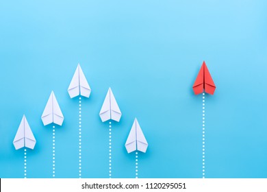 Group of paper plane in one direction and with one individual pointing in the different way on blue background. Business for innovative solution concept.