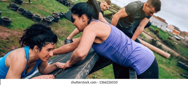 Group of participants in an obstacle course climbing a pyramid obstacle - Powered by Shutterstock