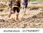 Group of participants in an obstacle course race running across a pool of water. Spartan race. Concept of hardness and effort