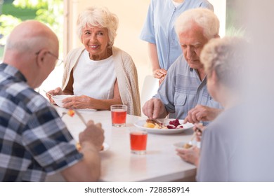 Group Of Pensioners Eating Lunch Together At The Rest Home