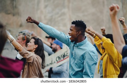 Group of people activists with raised fists protesting on streets, BLM demonstration concept. - Powered by Shutterstock