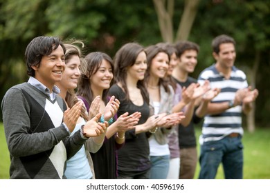 Group Of People Applauding And Smiling Outdoors