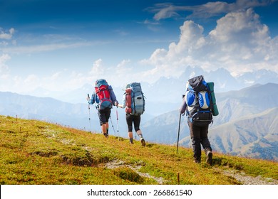 A group of people with backpacks walking on the trail