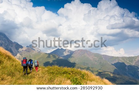 group of people with backpacks walking on the trail