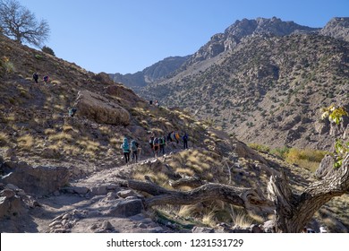 Group of people with big backpacks hiking on Mount Toubkal, Moroccow, heading for the peak of Atlas's highest mountain