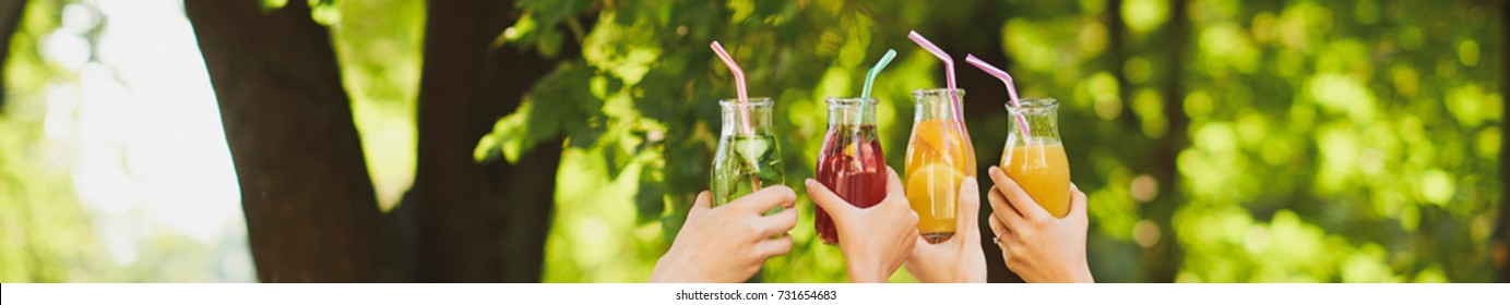 Group Of People Celebrate With Detox Juice Cocktails On Green Nature Background Witn Free Space. Diet On The Go, Well Being And Weight Loss, Superfoods, Health, Vegetarian Food Concept