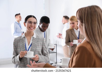 Group of people chatting during coffee break indoors - Powered by Shutterstock