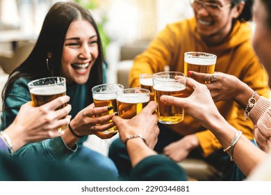 group of people cheering and drinking beer at bar pub table -Happy young friends enjoying happy hour at brewery restaurant-Youth culture-Life style food and beverage concept