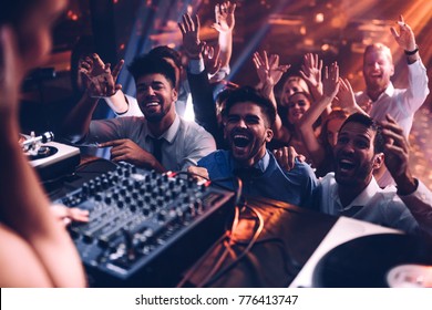 Group of people cheering in front of the DJ