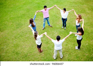 Group Of People In A Circle Holding Hands - Outdoors