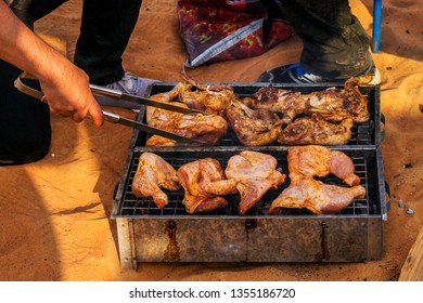 Group of people cooking chicken in the desert. - Powered by Shutterstock