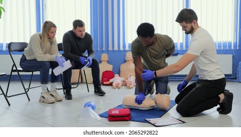 Group Of People CPR First Aid Training Course. CPR Teen Dummy First Aid Training.