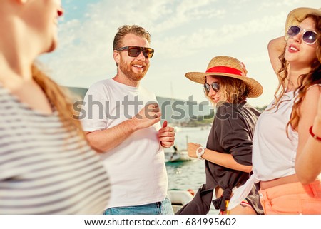Group of people dancing, chatting and having a good time at beach party