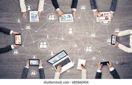 Grupo de personas con dispositivos en las manos trabajando juntos como símbolo de red y comunicación