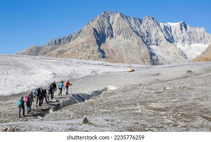 Group of people doing a guided glacier tour on the Great Aletsch Glacier (Marjelensee, Valais, Switzerland) - Powered by Shutterstock