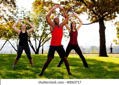 A group of people doing jumping jacks in the park - Powered by Shutterstock