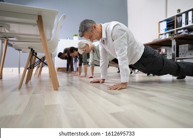 Group Of People Doing Pushups Exercise At Workplace - Powered by Shutterstock