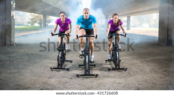 group of\
people doing spinning on cycle bike\
outdoor\

