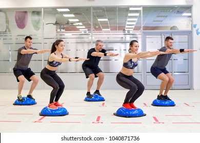 Group of people doing squats on bosu ball.  - Powered by Shutterstock