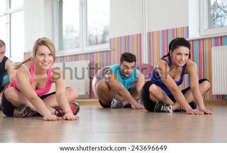Group of people doing stretching after workout