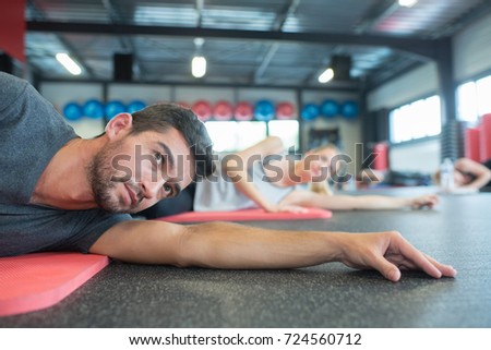 group of people doing stretching after workout