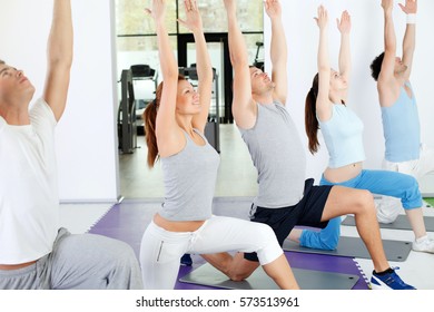 Group Of People Doing Yoga Exercise At Yoga Training Class.