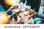 Group of people drinking beer at brewery pub restaurant - Happy friends enjoying happy hour sitting at bar table - Closeup image of brew glasses - Food and beverage lifestyle concept