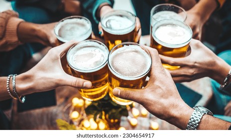 Group of people drinking beer at brewery pub restaurant - Happy friends enjoying happy hour sitting at bar table - Closeup image of brew glasses - Food and beverage lifestyle concept - Powered by Shutterstock