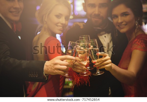 Group of people during celebration.\
Hands with a full glasses of sparkling wine.\
