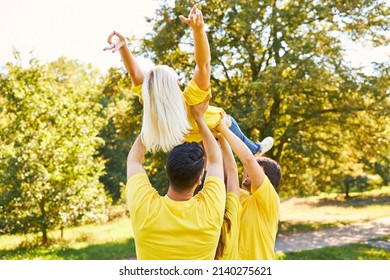 Group Of People During A Trust And Team Building Exercise Lifts One Woman Up