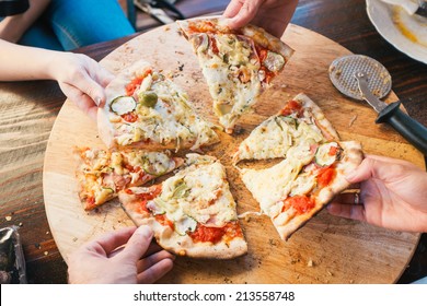 Group Of People Eating Delicious Pizza