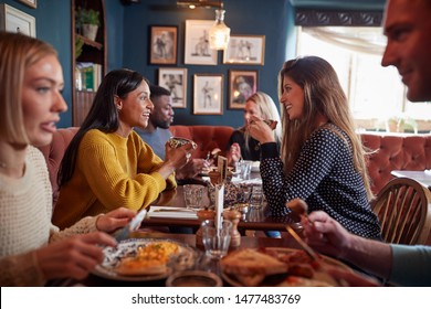 Group Of People Eating In Restaurant Of Busy Traditional English Pub