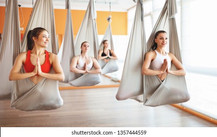 a group of people engaged in a class of yoga Aero in hammocks antigravity