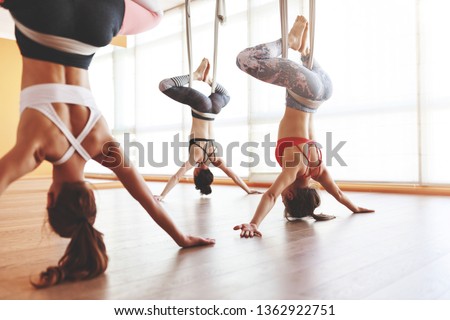 a group of people engaged in a class of yoga Aero in hammocks antigravity