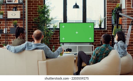 Group Of People Enjoying Movie On Television With Greenscreen Template, Having Fun At Gathering. Watching Cinema Tv Film With Isolated Chroma Key Background And Blank Mockup At Home.