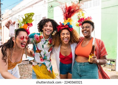 Group of people enjoying street Carnival festival. Friends laughing outdoors in costumes. - Shutterstock ID 2240360321