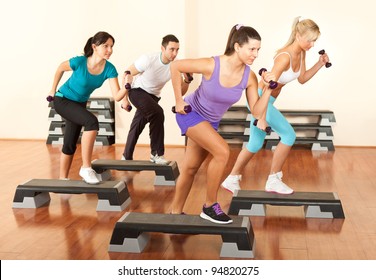 group of people exercising with dumbbells in the fitness club - Powered by Shutterstock