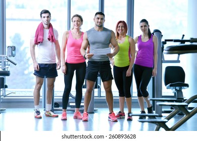 Group Of People Exercising At The Gym And Stretching