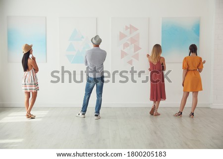 Group of people at exhibition in art gallery, back view