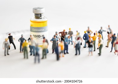 Group of people (figurine) standing against the Coronavirus COVID-19 vaccine and  syringe for injection .Coronavirus vaccine, population immunization campaign concept background.