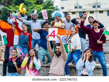 Group Of People With Four Sign Board And Indian Flags Shouting And Celebrating The Boundary While Watching Cricket Match At Stadium - Concept Of Excitement, Enjoyment And Cheerful Indian Crowd.