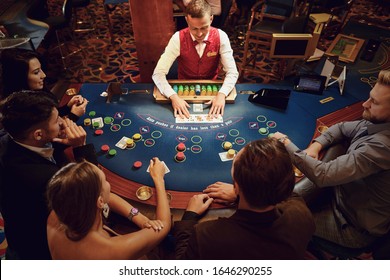 Group Of People Gambling Sitting At A Table In A Casino Top View