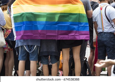 Group of people with gay rainbow flag at an LGBT gay pride march in London