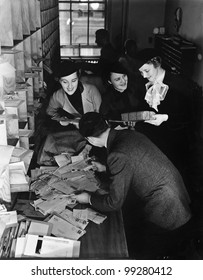 Group Of People Going Through A Pile Of Mail