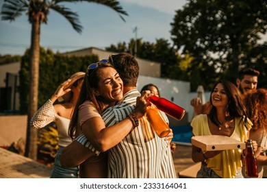 A group of people greet each other with hugs, handshakes, and high-fives, displaying their excitement - Powered by Shutterstock