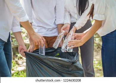 Group Of People Hands Putting Recycling Waste Bit To Black Garbage Bag Collection In Park .Environmental CSR Corporate Social Responsibility Concept .