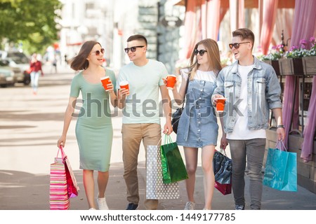 Group of people having fun and doing shopping. Friends with shopping bags.