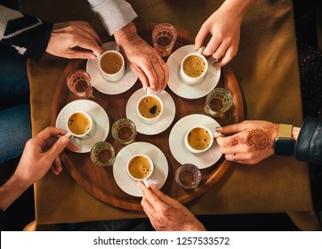 Group Of People With Henna Mehndi Tattoo On The Hands Drinking Turkish Coffey, Top View