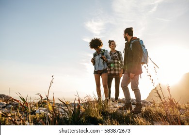 Group Of People Hiking In Nature On A Summer Day. Three Young Friends On A Country Walk.