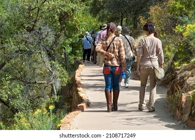 A Group Of People Hiking On A Pathway  Trail In Zion National Park, Utah, USA On A Sunny Day.
